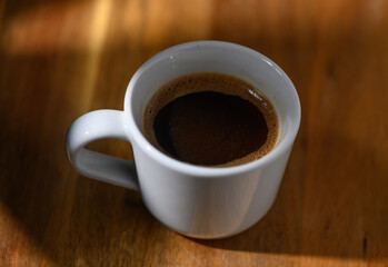 Enjoying rich coffee in a cozy setting while sunlight filters through a window