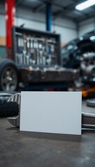 Blank business card on a wrench in a workshop, with a red toolbox and tools in the background, signifying mechanical or engineering professions.