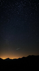 Fototapeta premium Starry night sky over a mountain range, constellations visible, with shooting stars crossing the sky Generative AI