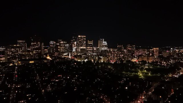 night aerial footage of the downtown city of Boston with buildings with lights