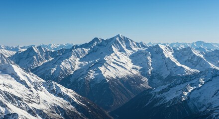 Fototapeta premium Majestic mountain range with snow-capped peaks and clear blue sky