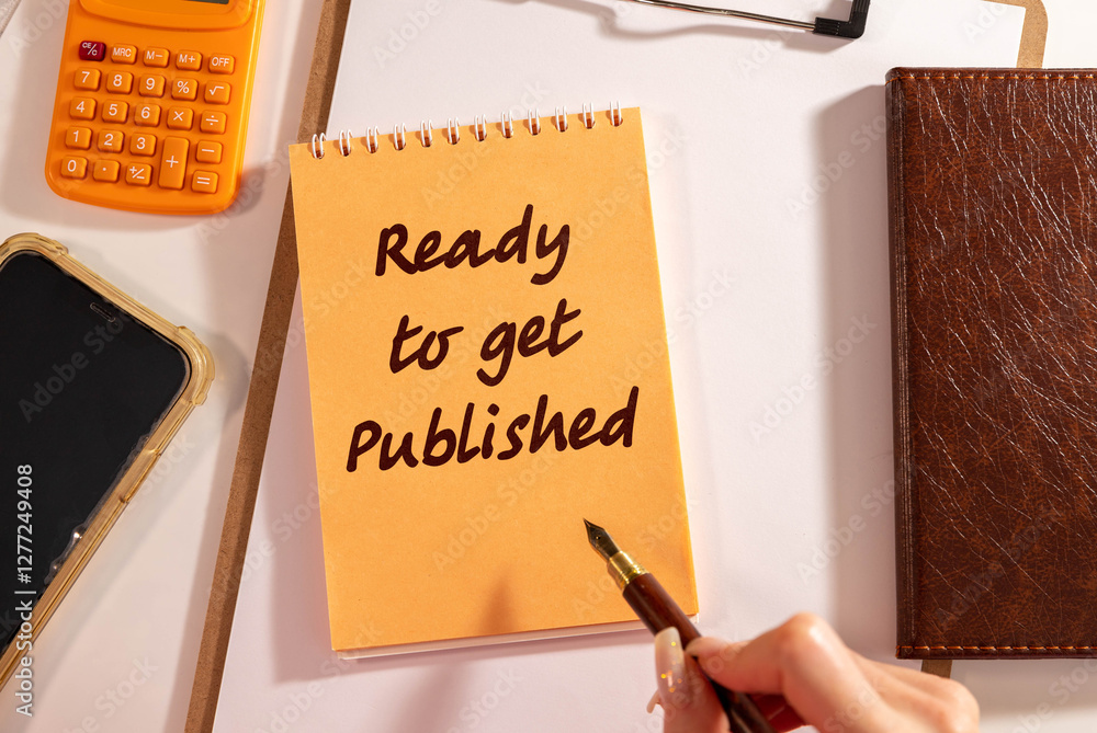 Poster a white notebook with red text ready to get published on a wooden desk.