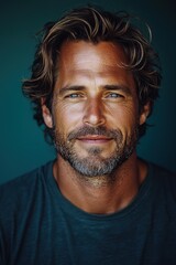 Fototapeta premium Man with tousled hair and a confident smile posed against a deep green background