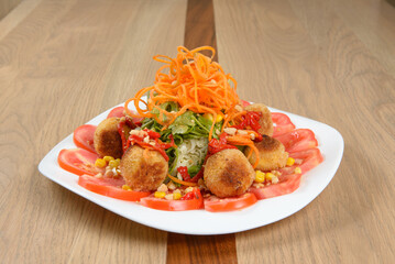Exquisite Salad: Fried spheres vibrant greens tomato slices and carrot threads create a delightful culinary work