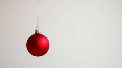 Vibrant Red Christmas Ornament Hanging Against a Simple Background