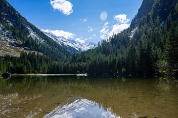 Crystal clear lake with snowed mountains in the back