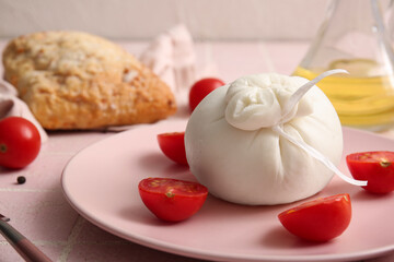 Plate with tasty Burrata cheese on table