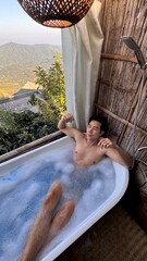 Handsome Asian Male Model Relaxing in Bathtub with Stunning Mountain View