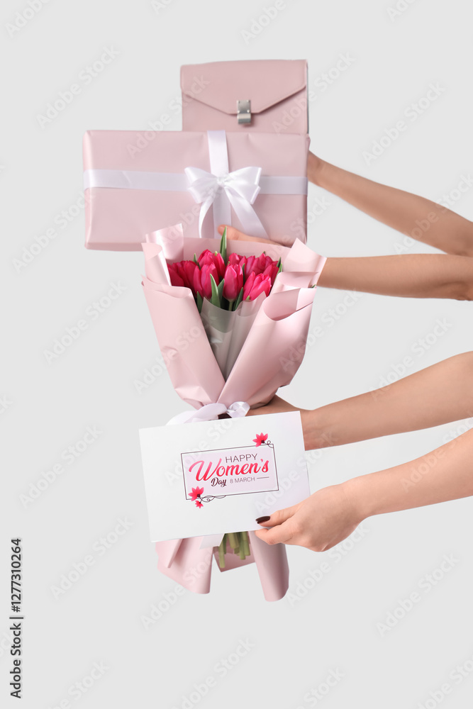 Sticker Female hands with bouquet of pink tulips, gift box and festive postcard on white background. Shopping for International Women's Day