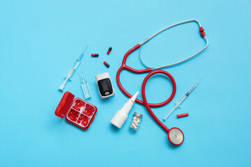 Composition with pulse oximeter, stethoscope and medicines on blue background