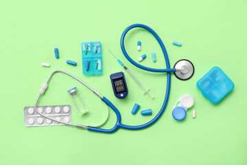 Composition with pulse oximeter, stethoscope and medicines on green background
