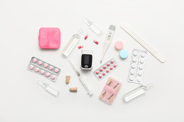 Composition with pulse oximeter, thermometer and medicines on white background