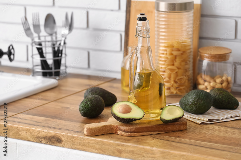 Canvas Prints Bottle of fresh oil and wooden board with avocado on kitchen counter