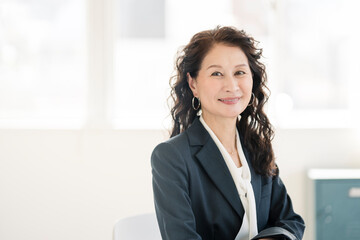 スーツを着たシニア世代の女性。