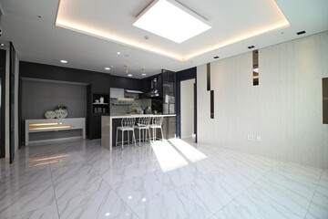 La sala de estar y la cocina están frente al interior de la estructura de una casa al estilo...