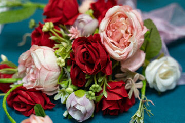 Beautiful assortment of artificial flowers on teal fabric