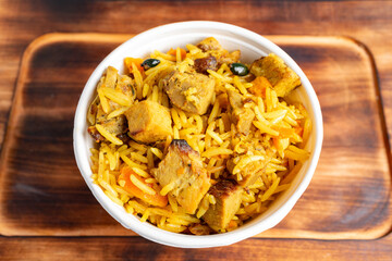 Delicious yellow rice dish with chicken and vegetables served in bowl
