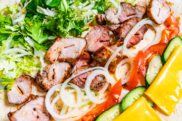 Fresh grilled meat is being sliced and arranged on a tortilla