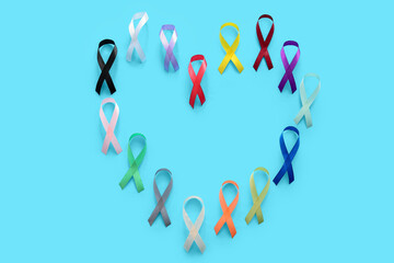 Heart made of different ribbons on color background. World Cancer Day