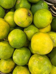 pile of green orange limes in the market