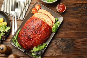 Delicious turkey meatloaf with vegetables served on wooden table, flat lay. Space for text