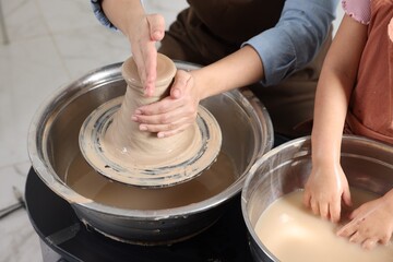 Hobby and craft. Mother with her daughter making pottery indoors, closeup