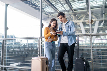 Asian young couple passenger standing outdoors of airport terminal.