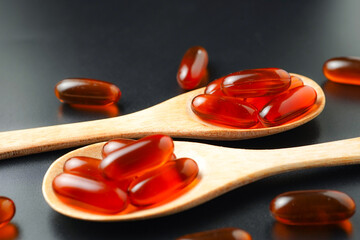 Vitamin capsules in a wooden spoon, soft gels, Fish oil capsules, omega 3, omega 9, vitamin D,...