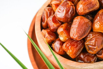 Dates fruit sukari or kurma sukari, in wooden bowl isolated on white background