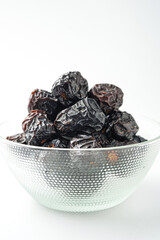 Dates fruit ajwa or kurma ajwa, in bowl isolated on white background