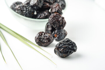 Dates fruit ajwa or kurma ajwa, in bowl isolated on white background