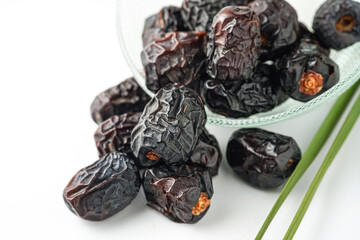 Dates fruit ajwa or kurma ajwa, in bowl isolated on white background