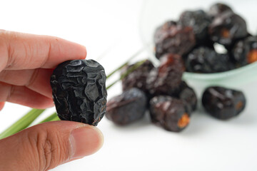Dates fruit ajwa or kurma ajwa, in hand isolated on white background