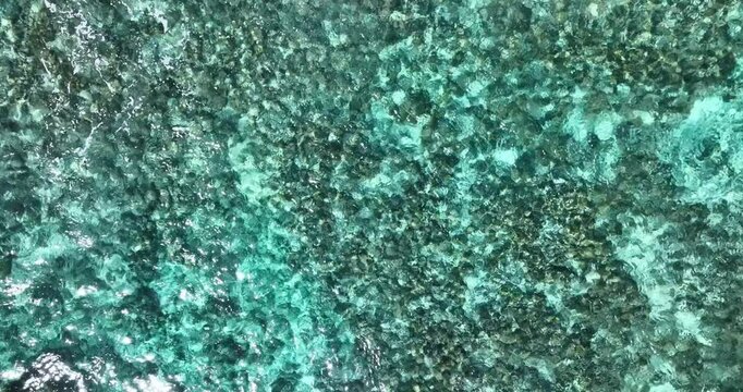 Vibrant turquoise caribbean sea water ripple texture pattern in natural day light aerial landscape