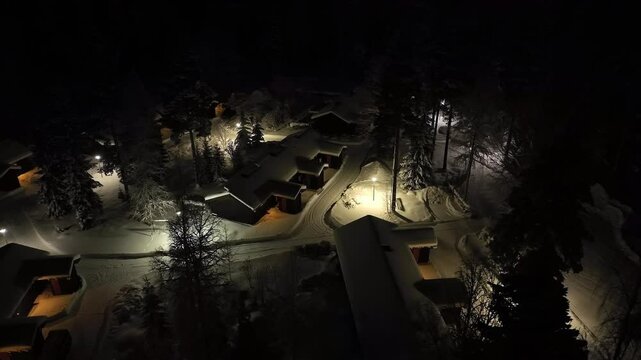 Aerial view of a illuminated cabin village, winter evening in Kainuu, Finland