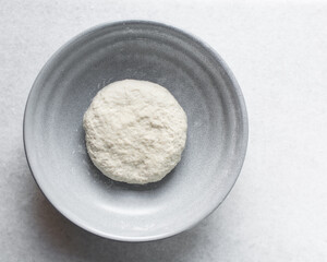 Overhead view of noodles dough in a grey bowl, top view of homemade biang biang noodles, process of making hand pulled noodles