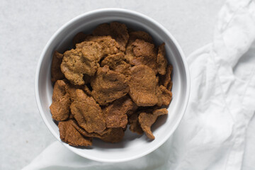 Overhead view of kuli-kuli in a white bowl, top view of nigerian groundnut cakes in a bowl