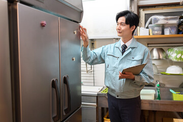 飲食店の冷蔵庫を確認する男性