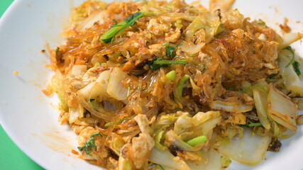 stir fried sukiyaki with egg and pork on white plate