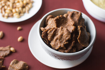 Overhead view of kuli-kuli in a white bowl, top view of nigerian groundnut cakes in a bowl