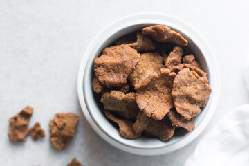 Overhead view of kuli-kuli in a white bowl, top view of nigerian groundnut cakes in a bowl