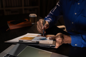 a businessman works overtime is his accounting firm's office until late at night, an entrepreneur remains at his export company because he has a lot of customer documents to check