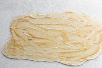 Overhead view of oil and flour mixture on raw chinese scallion pancakes dough, top view of homemade scallion pancakes, process of making cong you bing