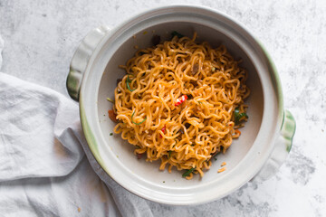 Overhead view of Spicy instant noodles in a claypot, spicy ramen noodles in a donabe