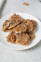 Overhead view of nigerian coconut candy on a white plate, top view of candied coconuts discs