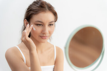 Beautiful Asian woman smile use cream for good skin. face of a healthy woman apply cream and...