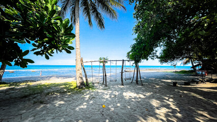 Beach view photo with wooden swing at Anyer Beach, Indonesia