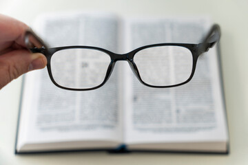 book and eye glasses for read and write over blurred background with copy space, reading glasses in...
