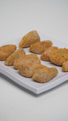 A plate of fried tahu walik is placed on a white base and background (isolated white).