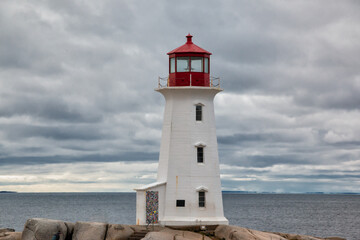 Peggy's Cove Lighthouse in Peggy's Cove, near Halifax, Nova Scotia, Canada. Rocky seaside maritime shores during a cloudy autumn day.